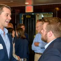 Alumni discuss by the bar